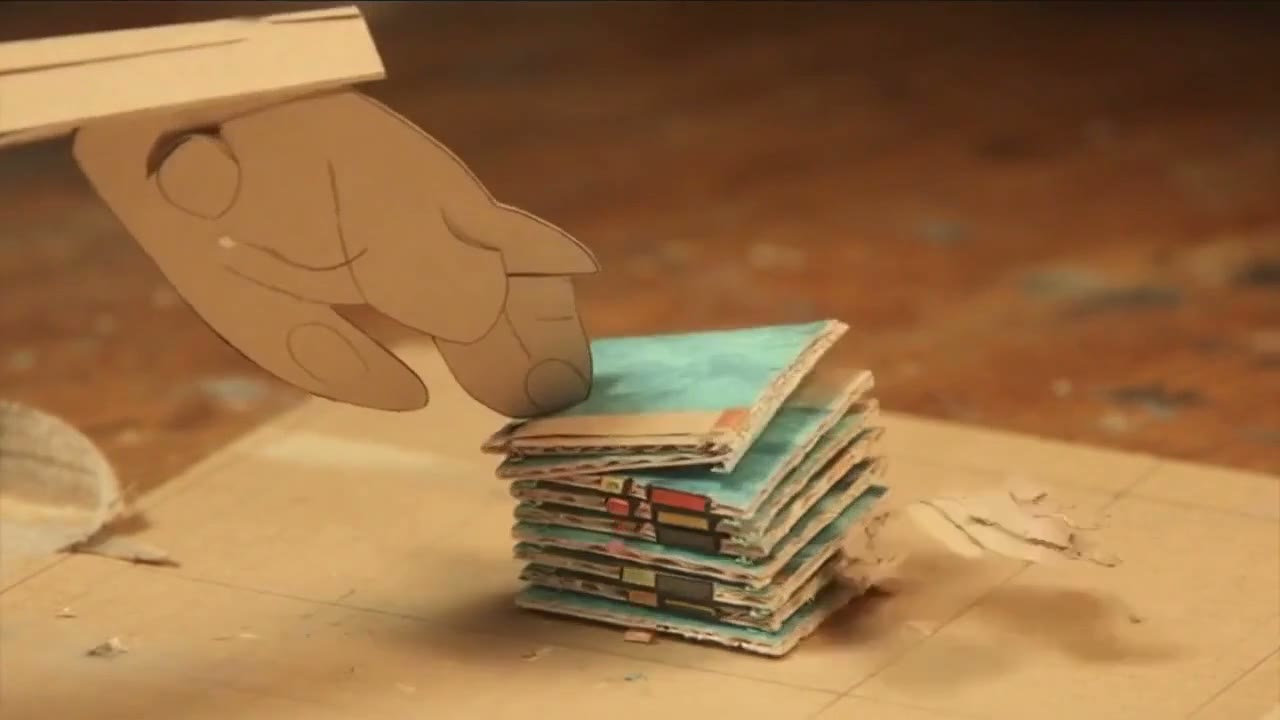 A paper-craft hand stacking labelled cardboard modules into place